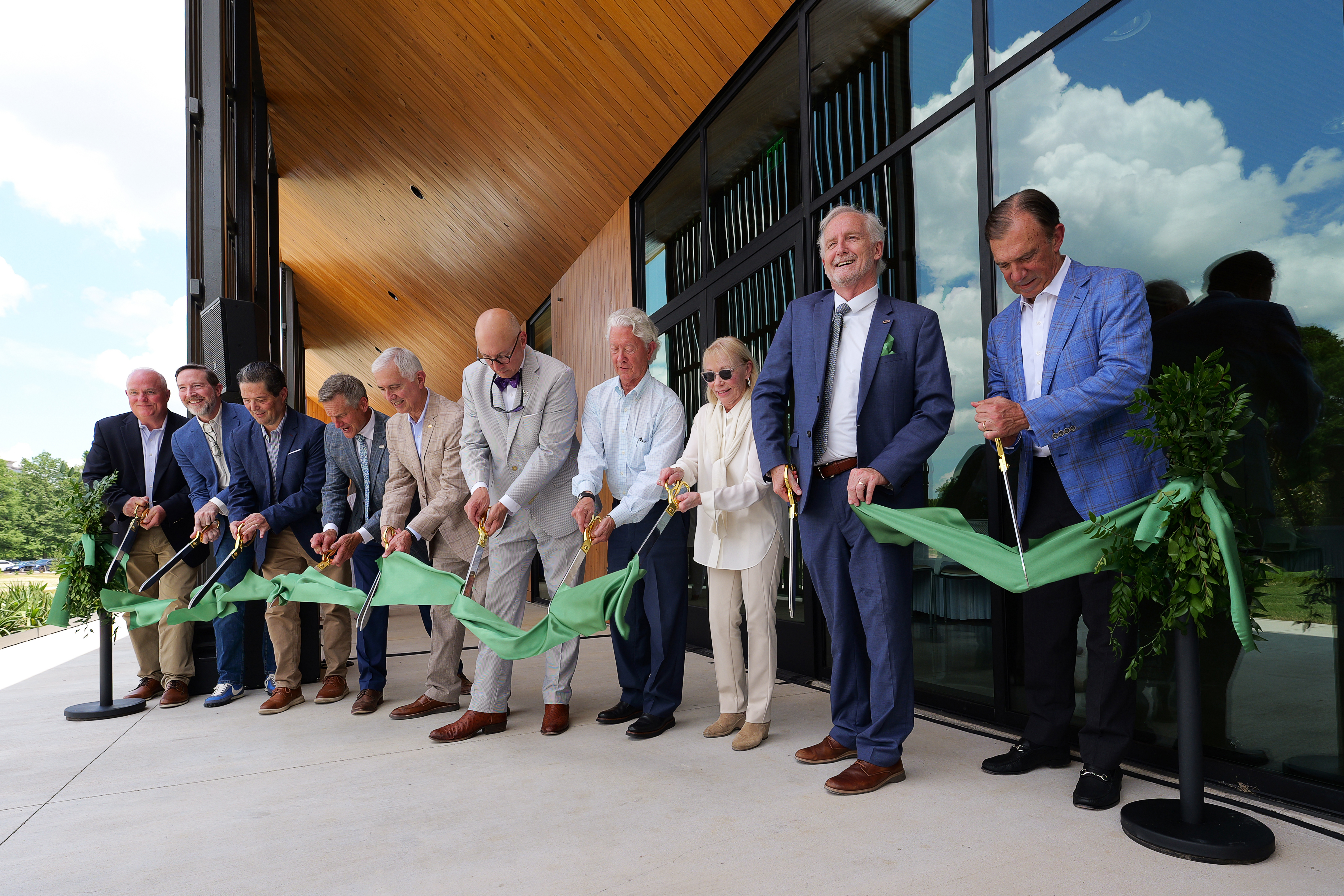 Group of people cutting a ceremonial ribbon.